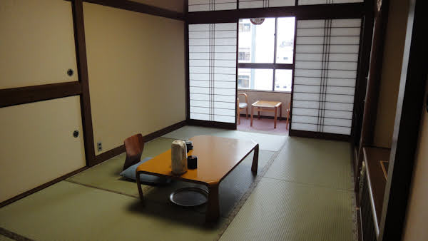 a typical japanese room with tatami mats, a low table, and sliding paper doors.